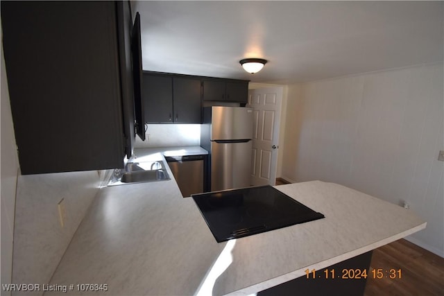 kitchen with dark hardwood / wood-style flooring, stainless steel fridge, sink, and black electric cooktop