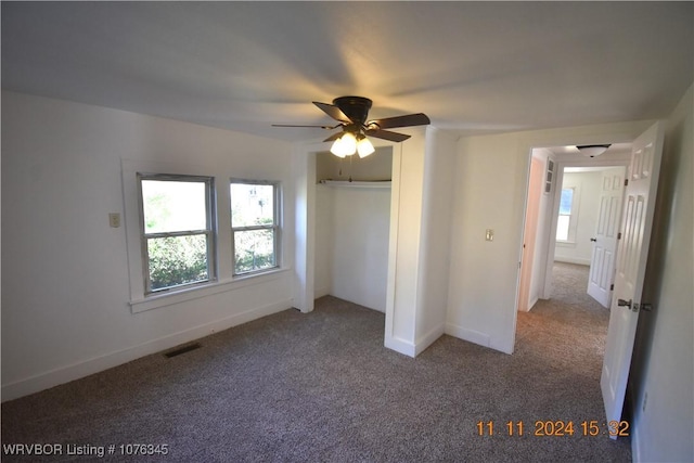 unfurnished bedroom with multiple windows, ceiling fan, a closet, and light carpet