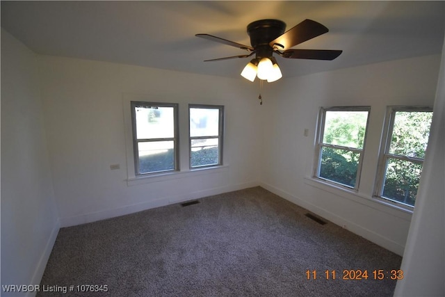 carpeted spare room featuring ceiling fan and a healthy amount of sunlight