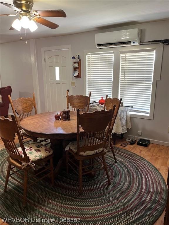 dining area with hardwood / wood-style floors, plenty of natural light, a wall mounted AC, and ceiling fan