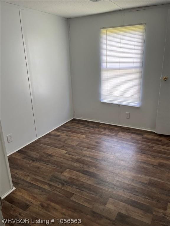 spare room with dark hardwood / wood-style flooring