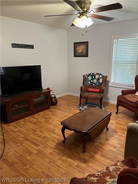 living room featuring ceiling fan and light hardwood / wood-style flooring