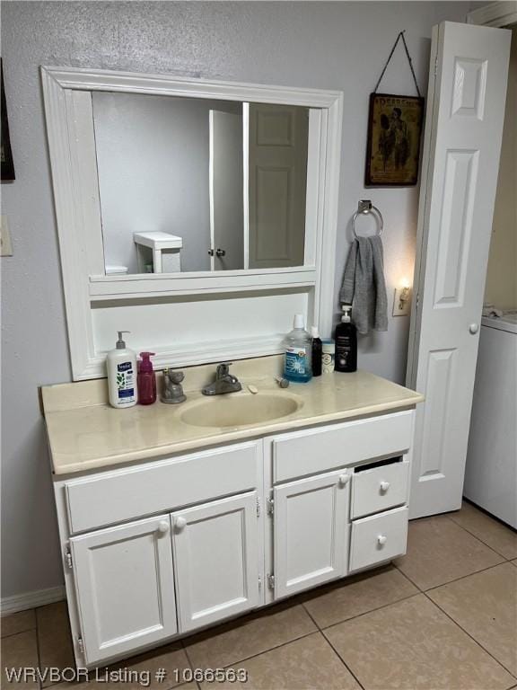 bathroom with toilet, vanity, and tile patterned floors