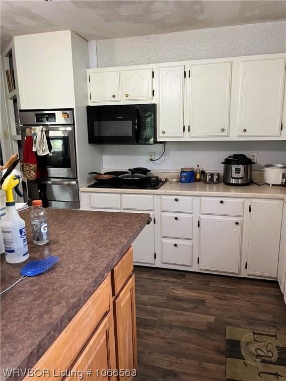 kitchen featuring white cabinets, dark hardwood / wood-style flooring, and black appliances