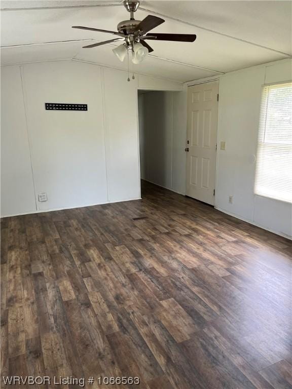 empty room with lofted ceiling, ceiling fan, and dark wood-type flooring