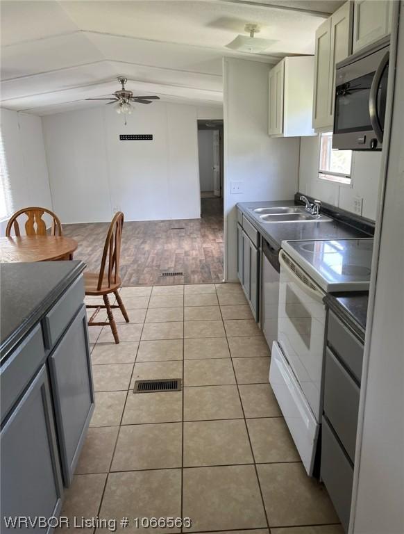 kitchen with sink, ceiling fan, gray cabinets, light tile patterned floors, and appliances with stainless steel finishes