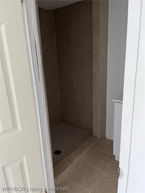 bathroom with tiled shower and tile patterned floors