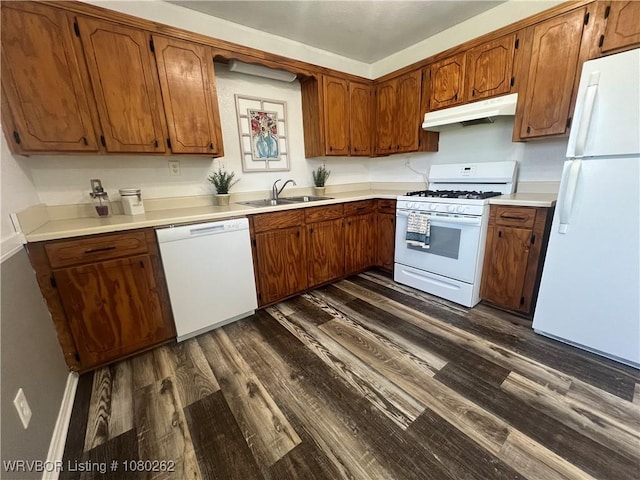 306 Dogwood, Pocola, OK 74902 - kitchen featuring white appliances, under cabinet range hood, dark wood-type flooring, brown cabinetry, and a sink