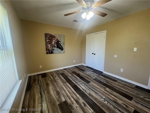 306 Dogwood, Pocola, OK 74902 - unfurnished bedroom featuring ceiling fan, a closet, dark wood-style flooring, and baseboards