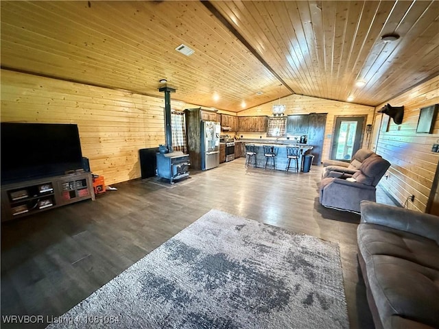 12878 128th St, Gore, OK 74435 - living area with wood walls, lofted ceiling, a wood stove, wood ceiling, and wood finished floors