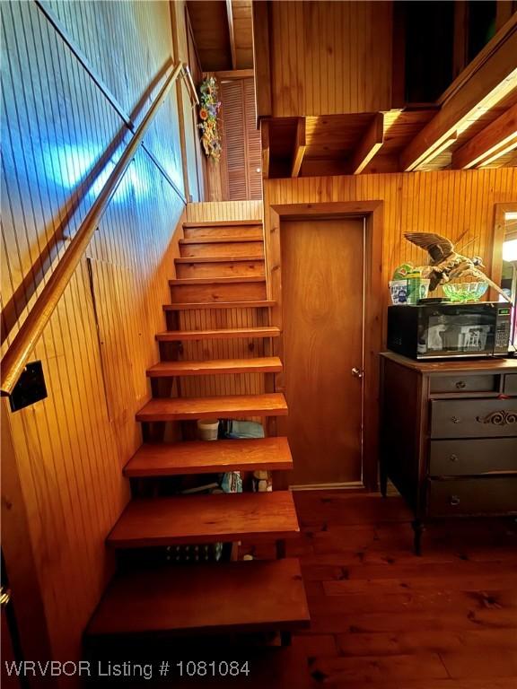 12878 128th St, Gore, OK 74435 - staircase with wooden walls and hardwood / wood-style flooring