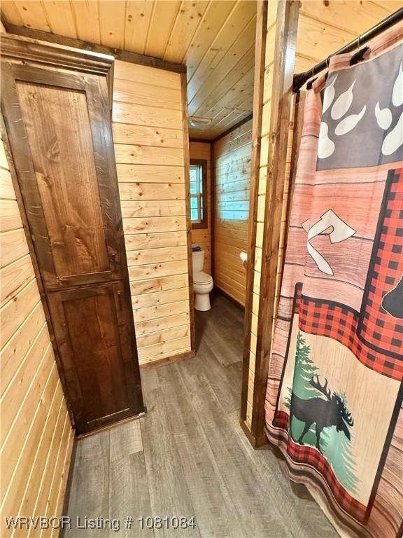 12878 128th St, Gore, OK 74435 - bathroom with wooden ceiling, wood walls, wood finished floors, and toilet