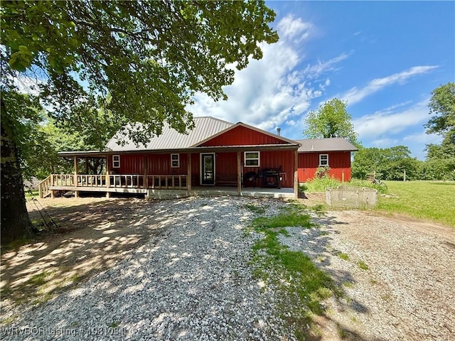 12878 128th St, Gore, OK 74435 - view of front of house with driveway, a wooden deck, board and batten siding, and metal roof