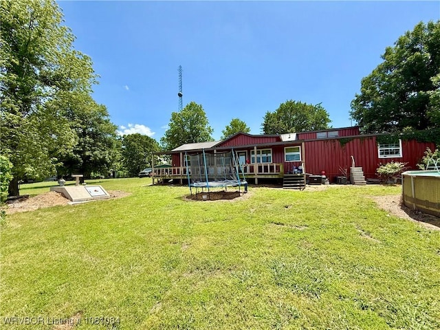 12878 128th St, Gore, OK 74435 - view of green lawn with a trampoline and a deck