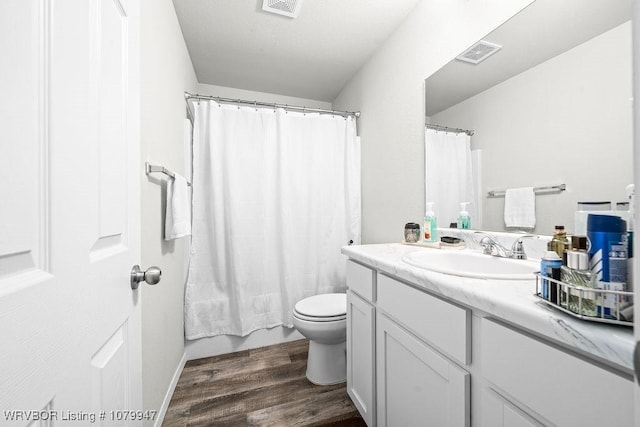 bathroom with visible vents, toilet, vanity, and wood finished floors
