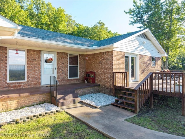 1003 Blair St, Pocola, OK 74902 - view of front of home featuring brick siding, a shingled roof, a wooden deck, and a porch