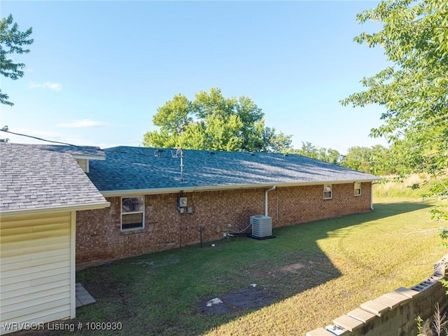 1003 Blair St, Pocola, OK 74902 - view of side of home with roof with shingles, a yard, central air condition unit, and brick siding