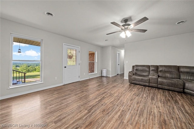 1003 Blair St, Pocola, OK 74902 - unfurnished living room featuring wood finished floors, healthy amount of natural light, and baseboards