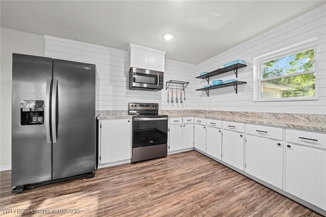 1003 Blair St, Pocola, OK 74902 - kitchen featuring appliances with stainless steel finishes, dark wood finished floors, white cabinetry, open shelves, and wooden walls