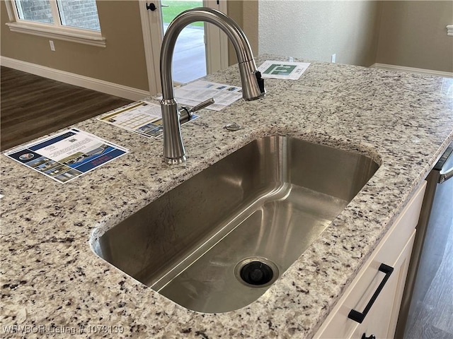 details featuring light stone counters and sink