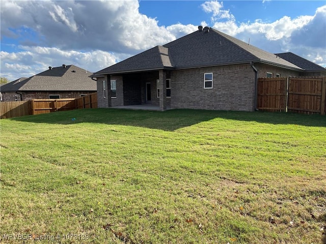 back of house with a yard and a patio area