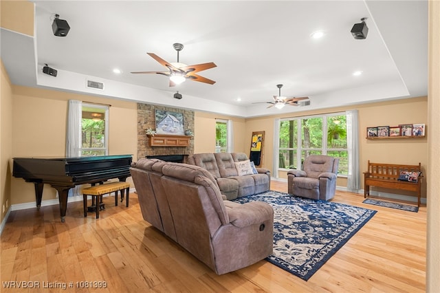 1760 N Ulmer St, Greenwood, AR 72936 - living room with a tray ceiling, light wood-style floors, ceiling fan, a large fireplace, and recessed lighting