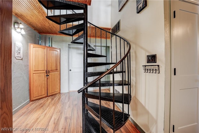 stairs with wood finished floors, visible vents, and baseboards