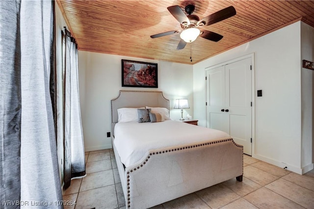 bedroom featuring baseboards, a ceiling fan, wood ceiling, a closet, and light tile patterned flooring