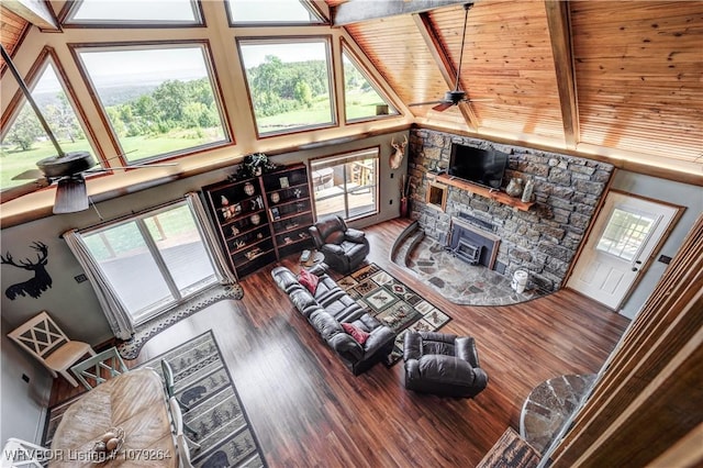 living room with a ceiling fan, beamed ceiling, high vaulted ceiling, and wood finished floors