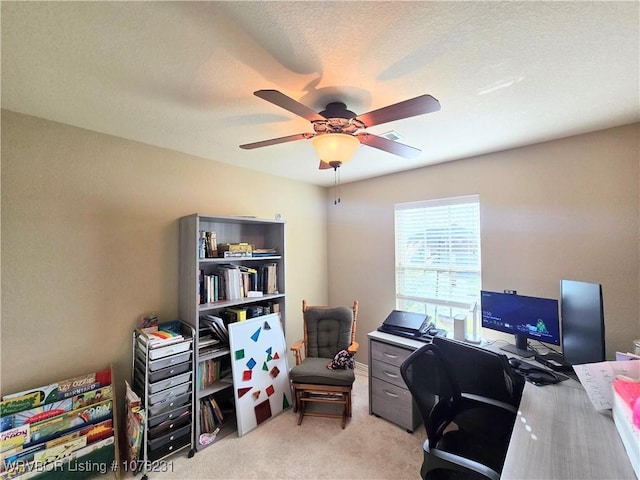 carpeted office with a textured ceiling and ceiling fan