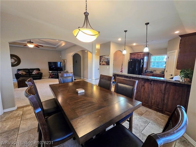 dining room featuring a raised ceiling, ceiling fan, and light tile patterned floors