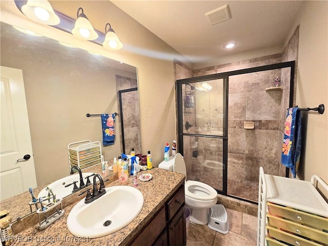 bathroom featuring vanity, toilet, and a shower with shower door