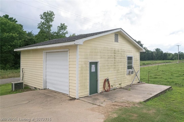 garage with central AC unit and a yard