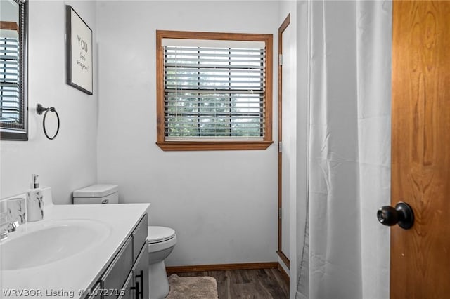 bathroom with curtained shower, toilet, vanity, and hardwood / wood-style flooring