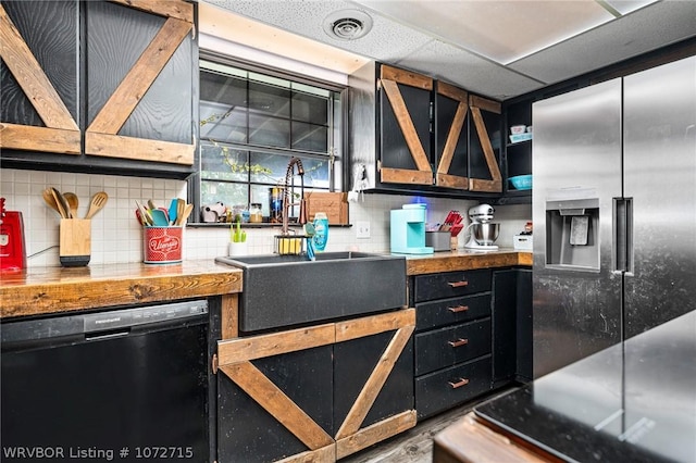 kitchen featuring a drop ceiling, sink, black dishwasher, tasteful backsplash, and stainless steel fridge with ice dispenser