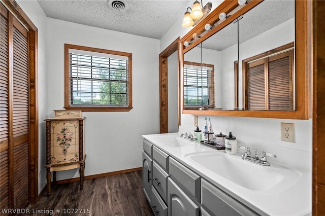 bathroom featuring hardwood / wood-style floors, vanity, and a textured ceiling