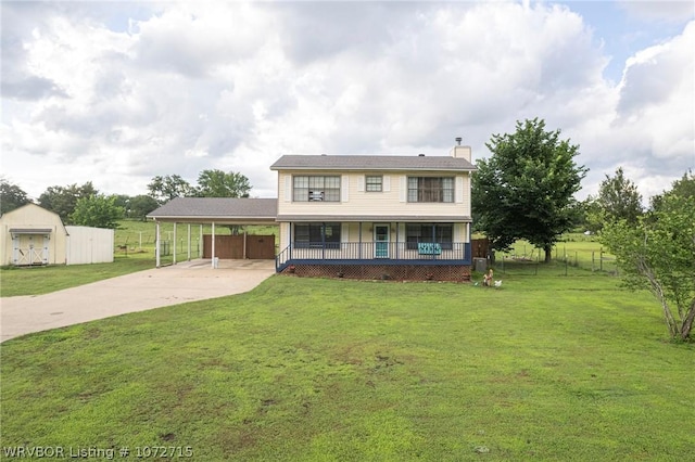 view of front of house with a front lawn, a carport, and an outdoor structure