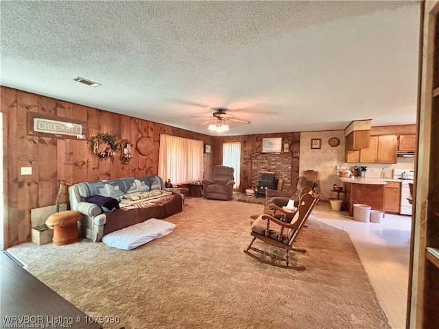 5525 Slaytonville Rd, Hackett, AR 72937 - living room featuring ceiling fan, a textured ceiling, visible vents, and wooden walls
