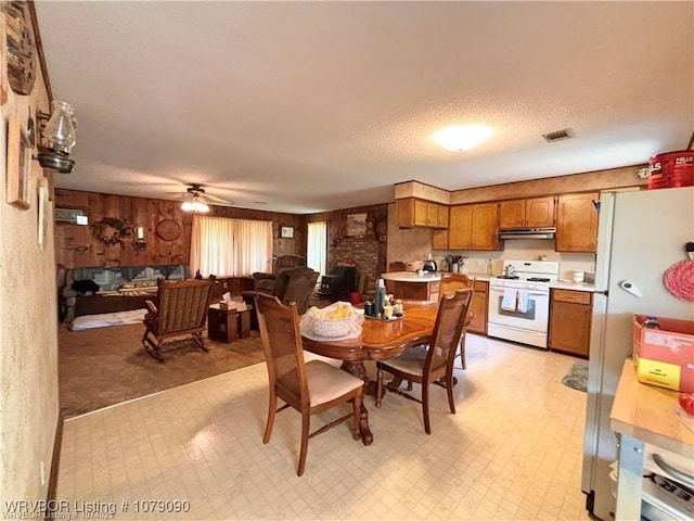 5525 Slaytonville Rd, Hackett, AR 72937 - dining area with a fireplace, light floors, visible vents, ceiling fan, and a textured ceiling