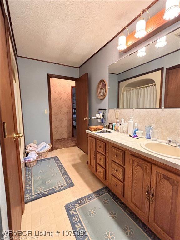 5525 Slaytonville Rd, Hackett, AR 72937 - bathroom with double vanity, a sink, a textured ceiling, and tile patterned floors