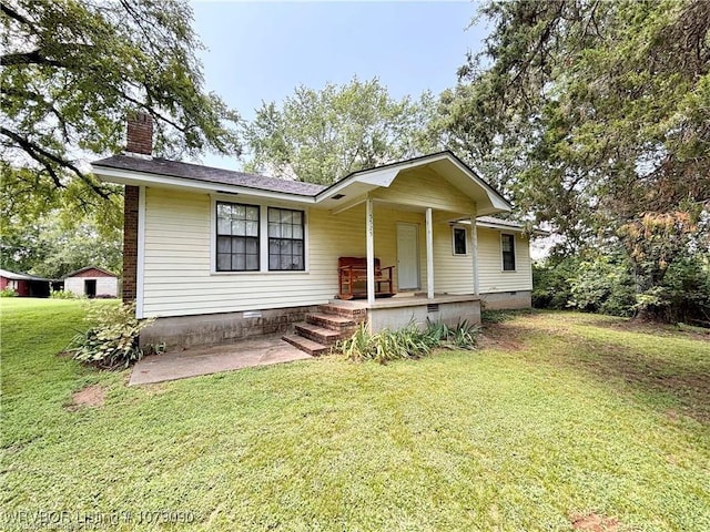 view of front of home featuring crawl space, covered porch, a chimney, and a front lawn