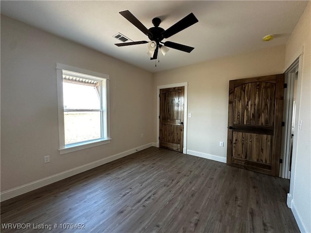 unfurnished bedroom featuring visible vents, baseboards, ceiling fan, and dark wood-style flooring