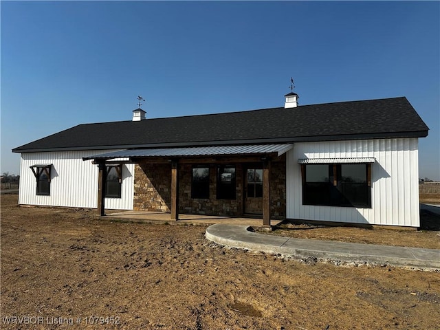 rear view of property with stone siding