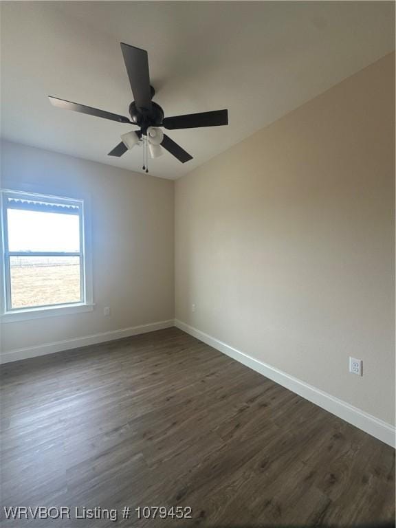 empty room with dark wood-style floors, a ceiling fan, and baseboards