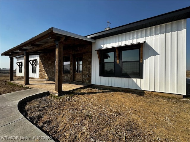 view of front facade with stone siding and a patio