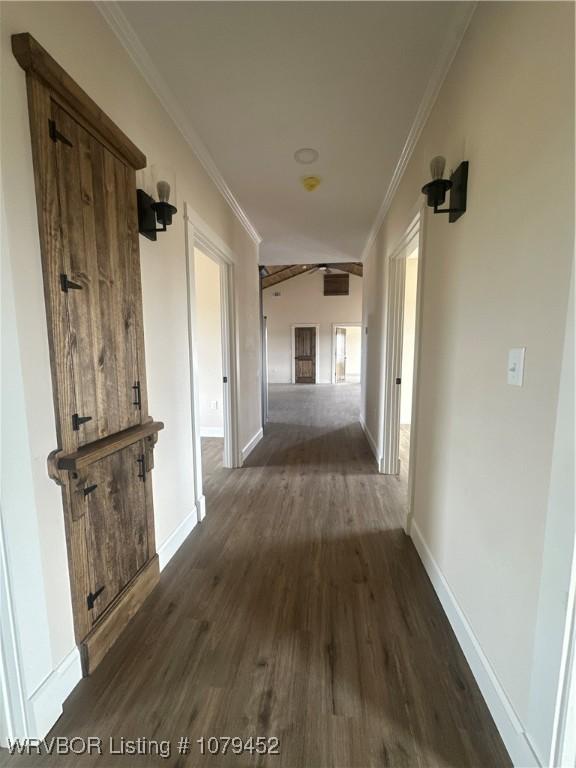 corridor featuring baseboards, dark wood-style flooring, and crown molding