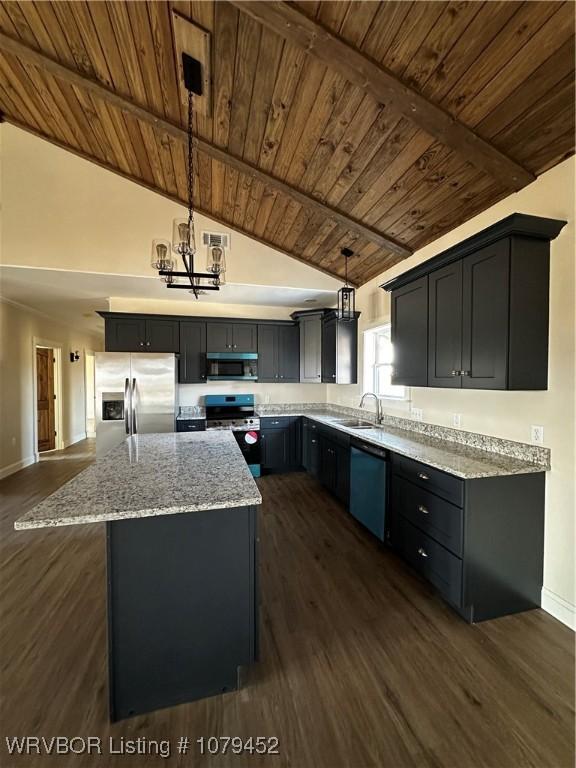 kitchen featuring light stone counters, dark wood-style flooring, appliances with stainless steel finishes, a sink, and a kitchen island