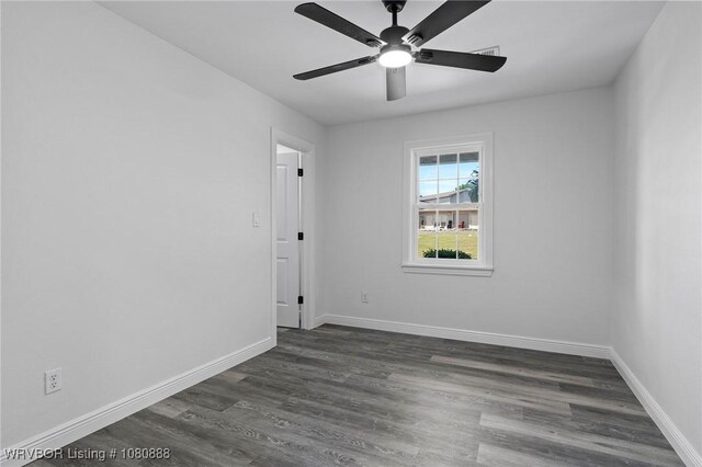 unfurnished room featuring dark wood finished floors, baseboards, and ceiling fan