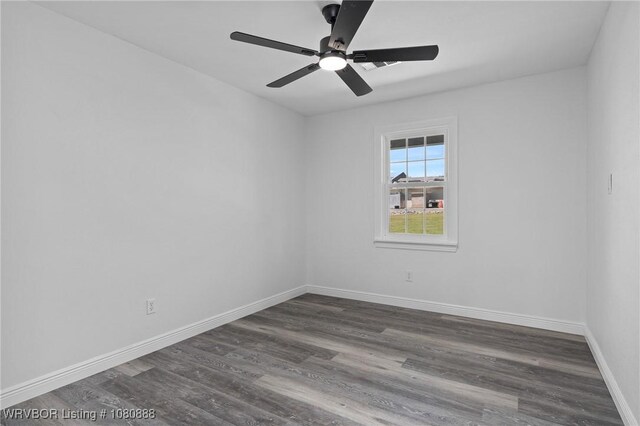 unfurnished room with dark wood-type flooring, baseboards, and a ceiling fan