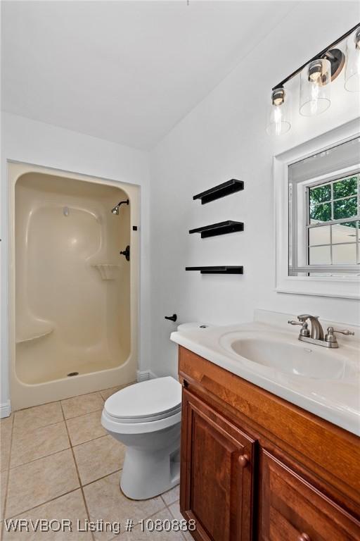 full bathroom with a shower, tile patterned floors, vanity, and toilet